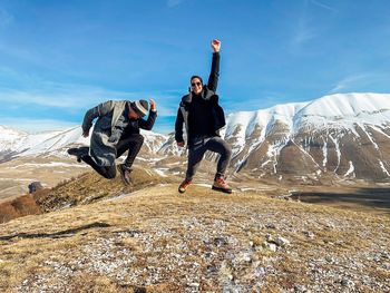 Men jumping on snowy mountain