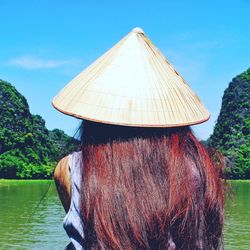 Rear view of woman with conical hat at lake