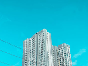 Low angle view of modern building against blue sky