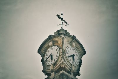 Low angle view of weather vane against sky