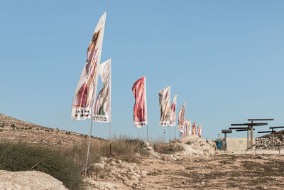 Low angle view of flags against clear sky