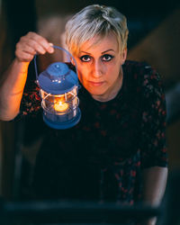 Portrait of woman holding illuminated candle