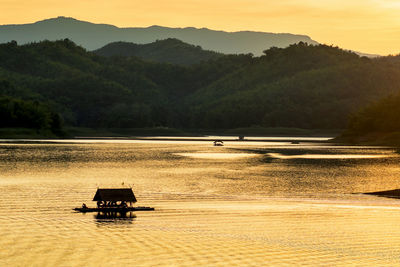 Silhouette boat on beach against sky during sunset