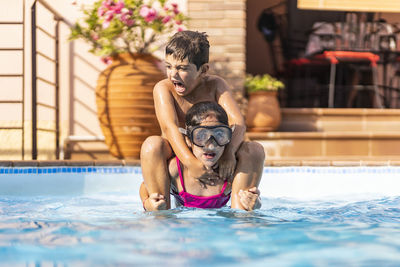 Two kids playing in a swimming pool