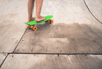 Low section of child playing with skateboard