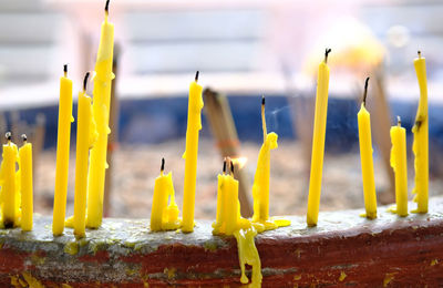 Close-up of yellow candles on temple