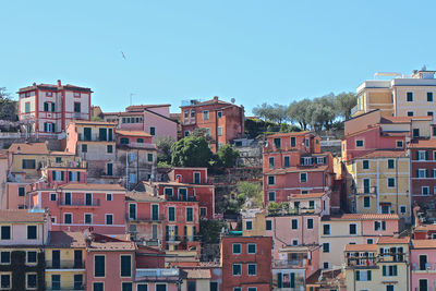 Buildings in city against clear blue sky