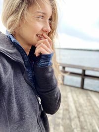 Smiling woman standing by sea