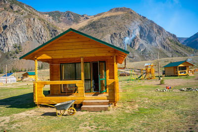 House on field against mountain