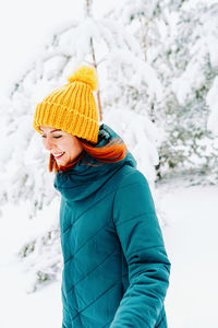 Portrait of boy standing on snow covered field