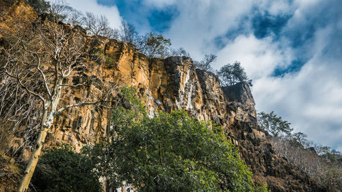 Low angle view of rocks on mountain against sky