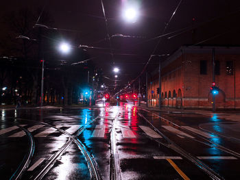 Road passing through illuminated city at night