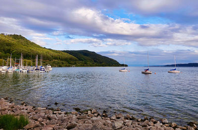 Sailboats on sea against sky