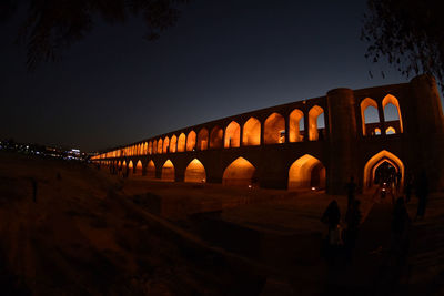 Low angle view of illuminated bridge against clear sky at night