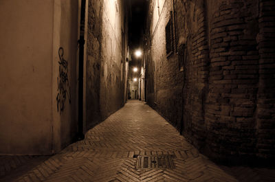Empty narrow alley along buildings