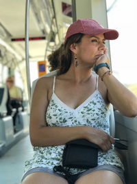 Woman looking away while sitting in tram