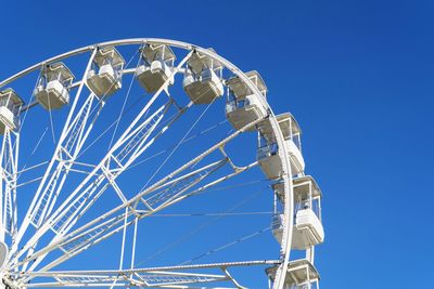 Low angle view of ferris wheel against blue sky