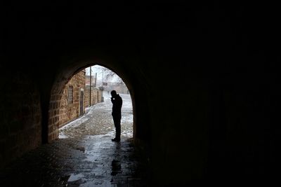 Silhouette man standing at archway