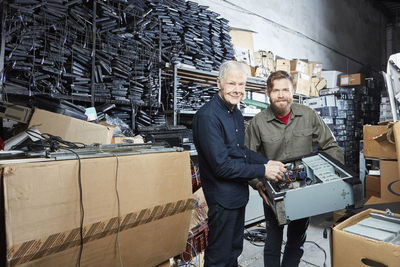 People workinhg in storage of computer recycling plant