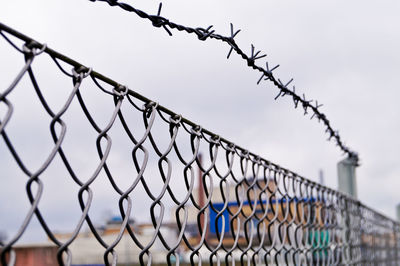 Close-up of chainlink fence against sky