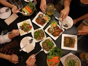 High angle view of people having food in dining table