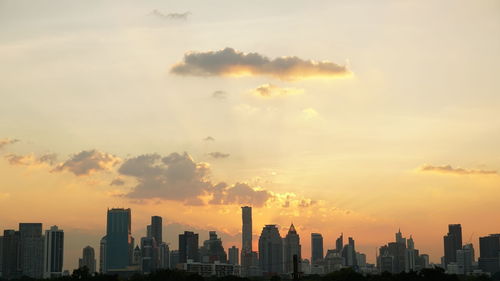 Modern buildings against sky during sunset