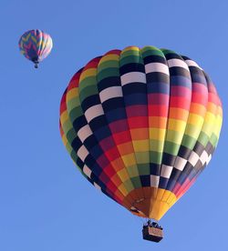 Low angle view of hot air balloons against blue sky