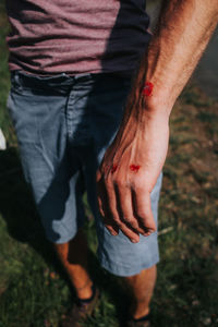 Low section of man standing on field