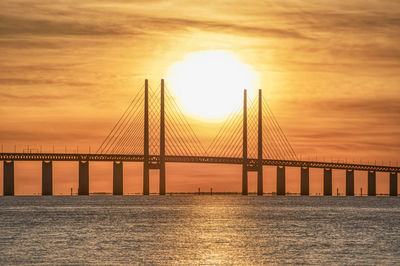 View of suspension bridge over sea during sunset