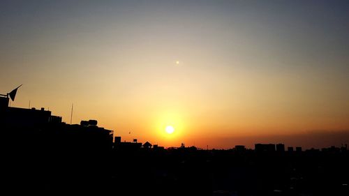 Silhouette buildings against sky during sunset