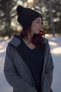 Beautiful young woman standing in snow