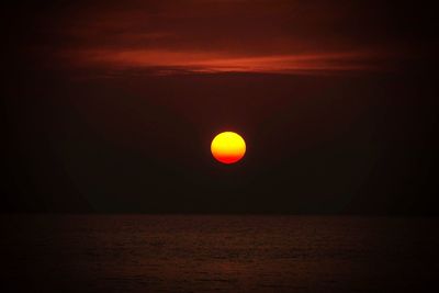 Scenic view of sea against dramatic sky during sunset