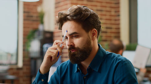 Side view of young man smoking cigarette