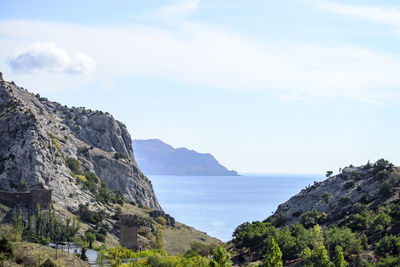 Scenic view of sea and mountains against sky