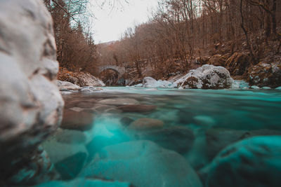 Surface level of river flowing through rocks during winter