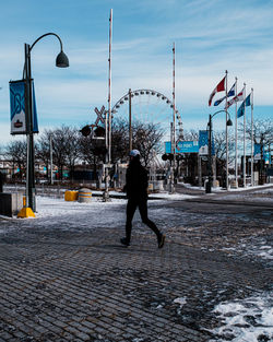 Rear view of man walking on street in winter