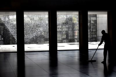 Silhouette man standing by window in building