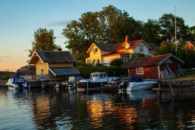 Houses by river and buildings against sky