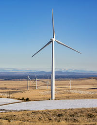 Wind turbines in a field with clear sky