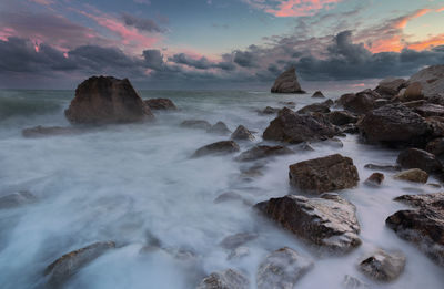 Scenic view of rocks in sea against sky