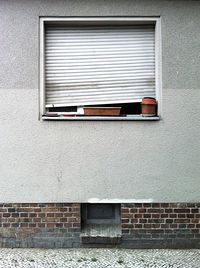 View of brick wall with closed shutter