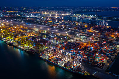 Night scene container ship loading and unloading in deep sea port, aerial view of business service 