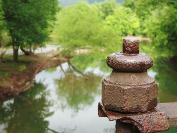 Close-up of old rusty metal by lake