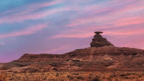 Rock formations on landscape against sky during sunset