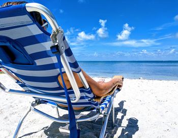 Man sitting chair in front of sea at beach