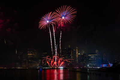 Firework display over city at night