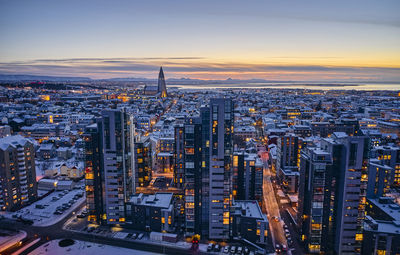 Illuminated apartment buildings in winter evening in city