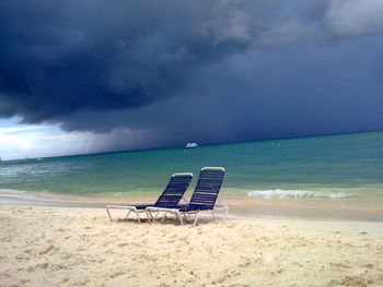 Chair on beach against sky