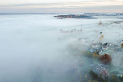 Aerial view of town in foggy weather against sky