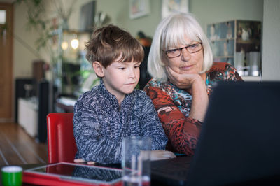 Grandmother and grandson sitting at restaurant 